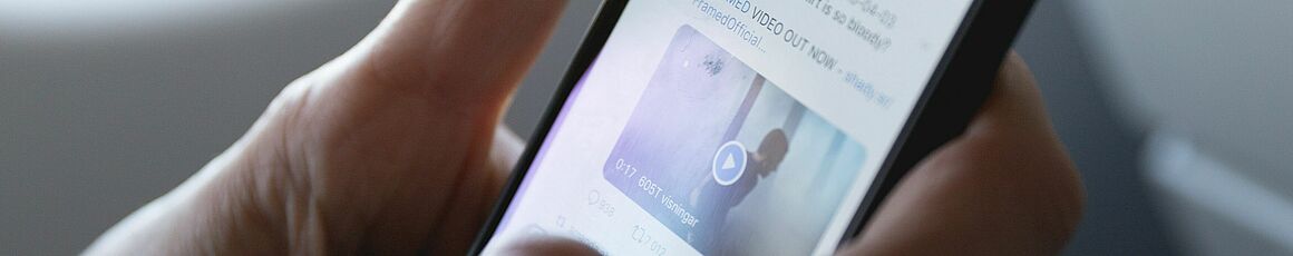Person prüft Social Media Kanal am Mobiltelefon